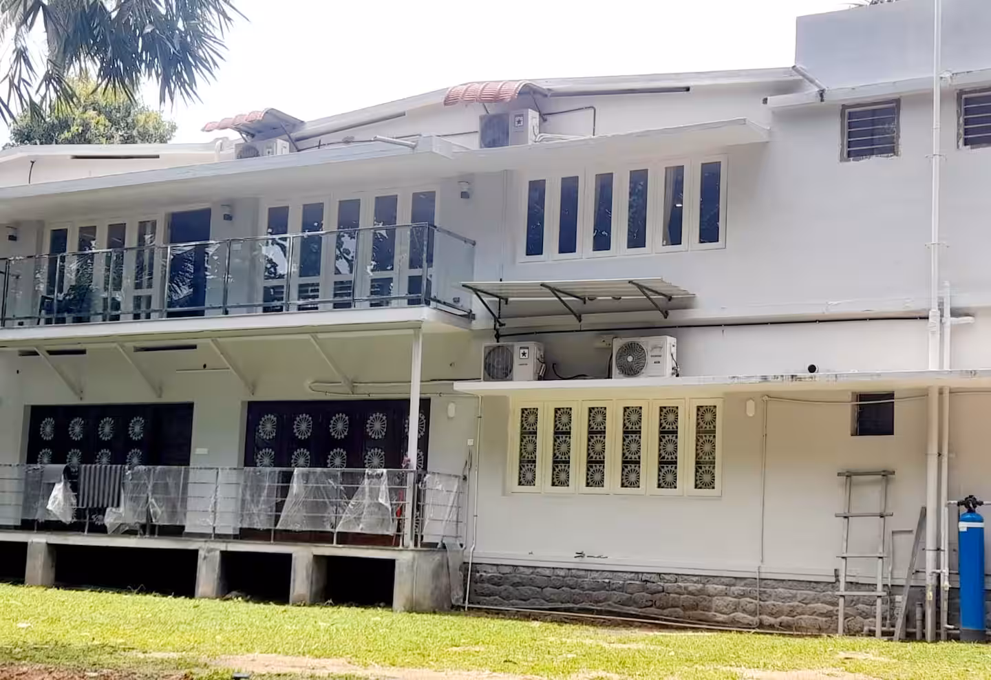 Expansive green lawn and exterior view of Riverside Retreat homestay in Thiruvalla